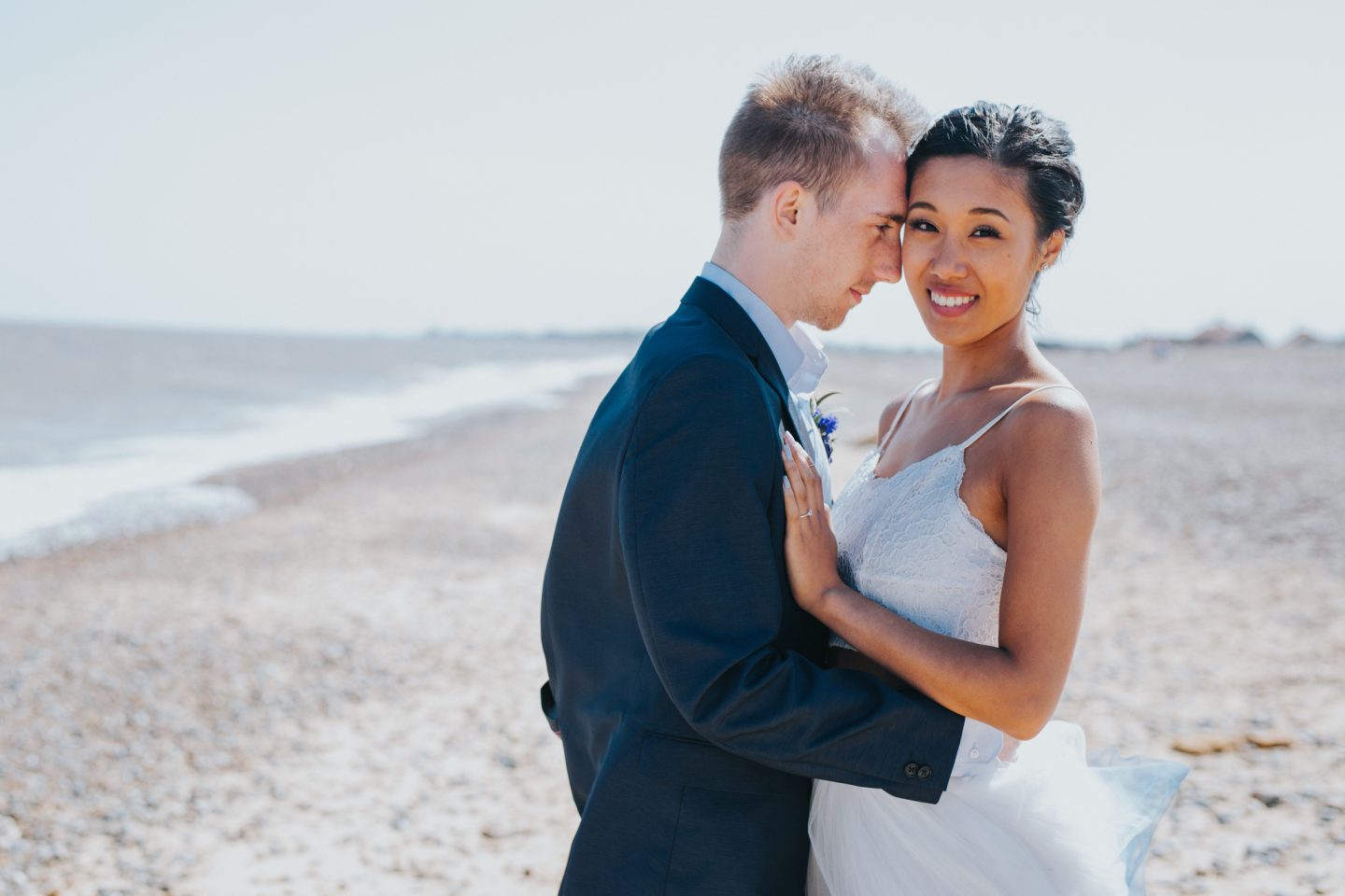 beach wedding couple holding each other in an embrace after their ceremony.
