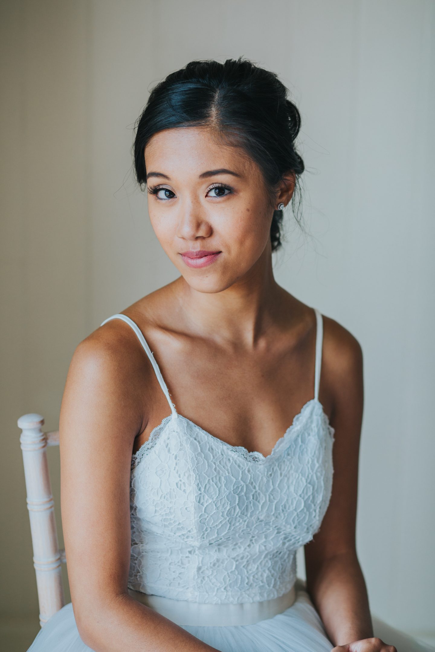 Bride sitting in chair after hving her makeup applied for her wedding.